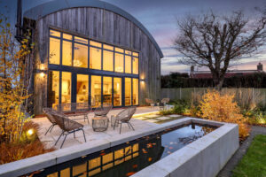 A cabin -like house with long windows with a pond and sunset. A two-floor house surrounded by nature, Alexander says thank you for visiting the page.